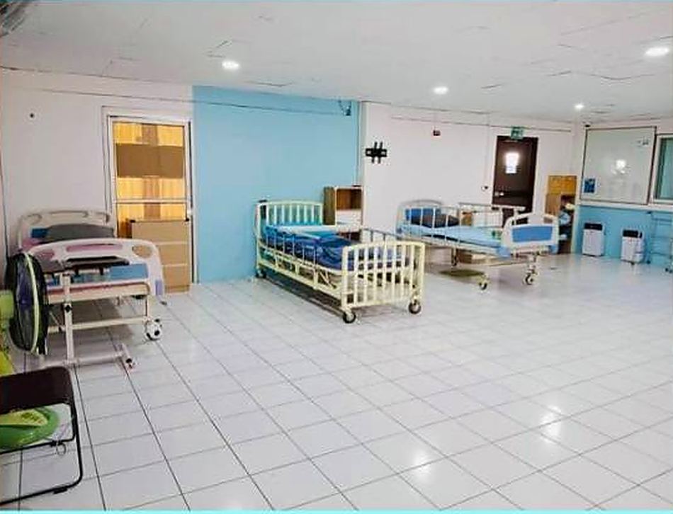 ห้องพักรวมพร้อมเตียงพยาบาลปรับระดับ พื้นกระเบื้องเรียบ และพื้นที่ว่างสำหรับรถเข็น